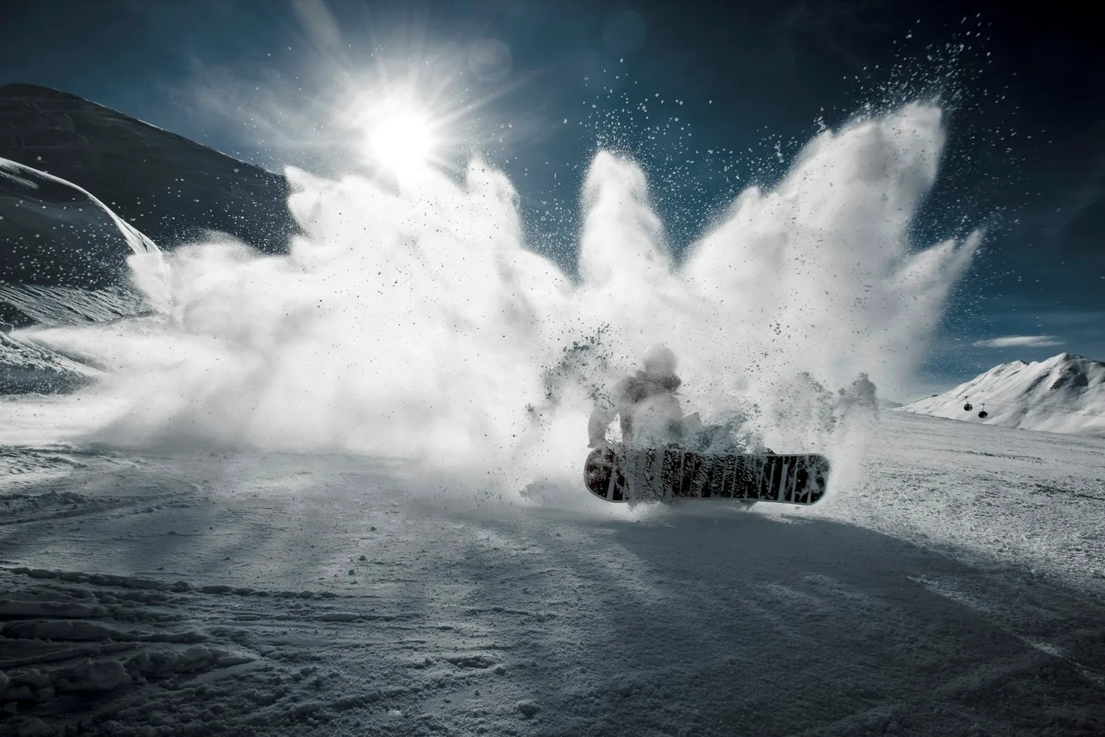 A snowboarder kicking up a huge cloud of snow