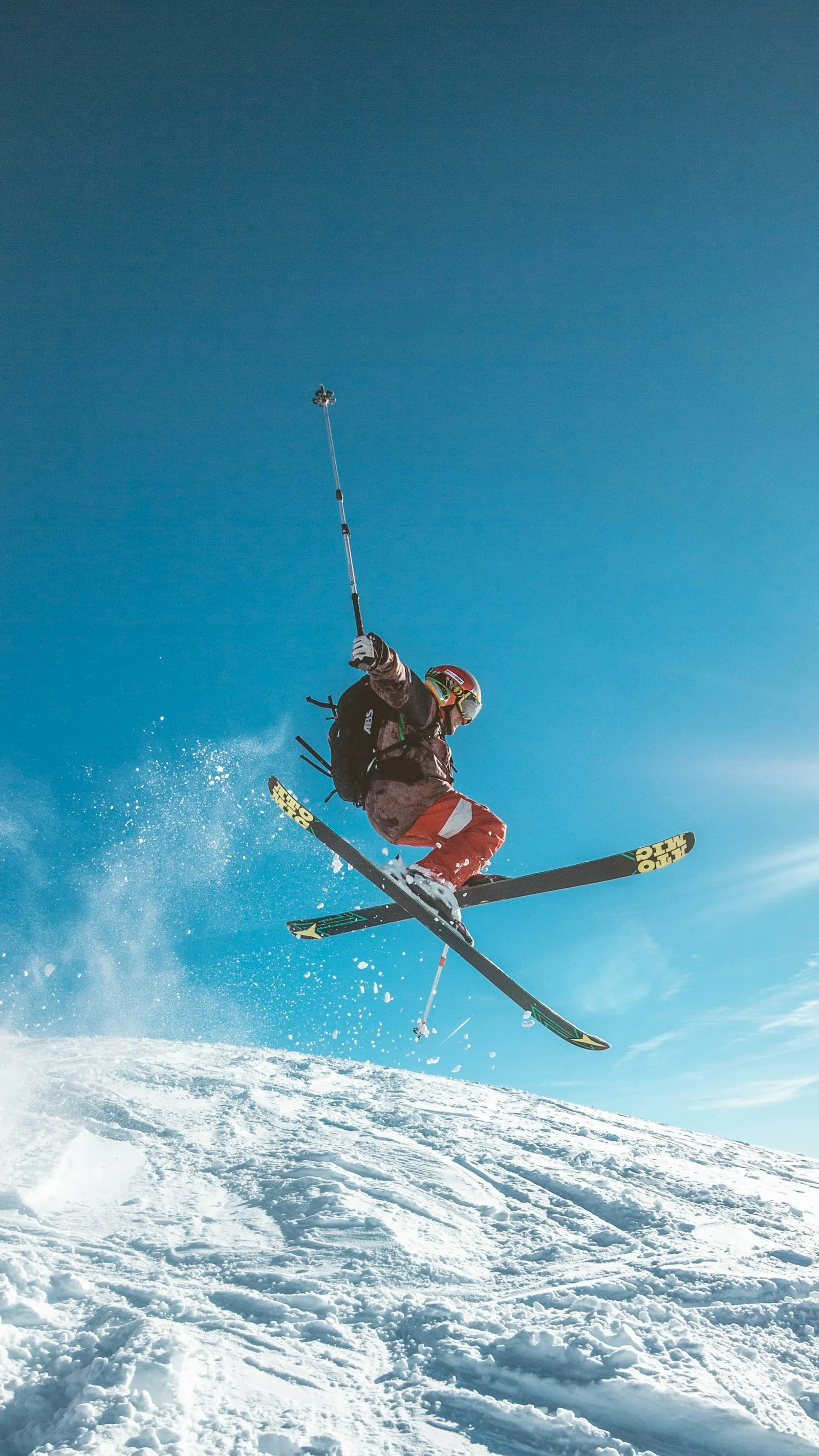 A skier in the air against a bright blue sky
